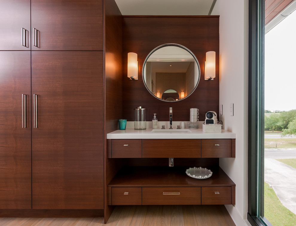 Immagine di una stanza da bagno padronale design con lavabo sottopiano, ante lisce, ante in legno bruno e pareti bianche