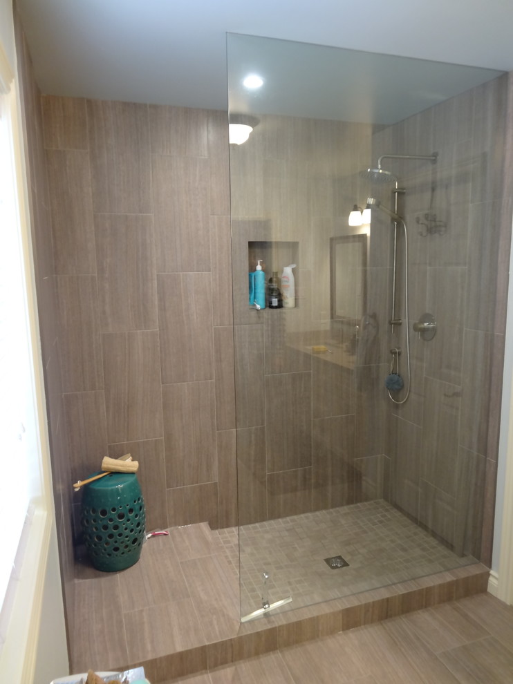 Trendy beige tile and porcelain tile alcove shower photo in Toronto with an undermount sink, a two-piece toilet, recessed-panel cabinets and solid surface countertops