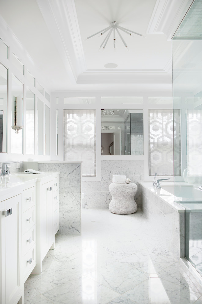 Идея дизайна: главная ванная комната в стиле неоклассика (современная классика) с фасадами с утопленной филенкой, белыми фасадами, полновстраиваемой ванной, белой плиткой, мраморной плиткой, белыми стенами, мраморным полом, белым полом и белой столешницей