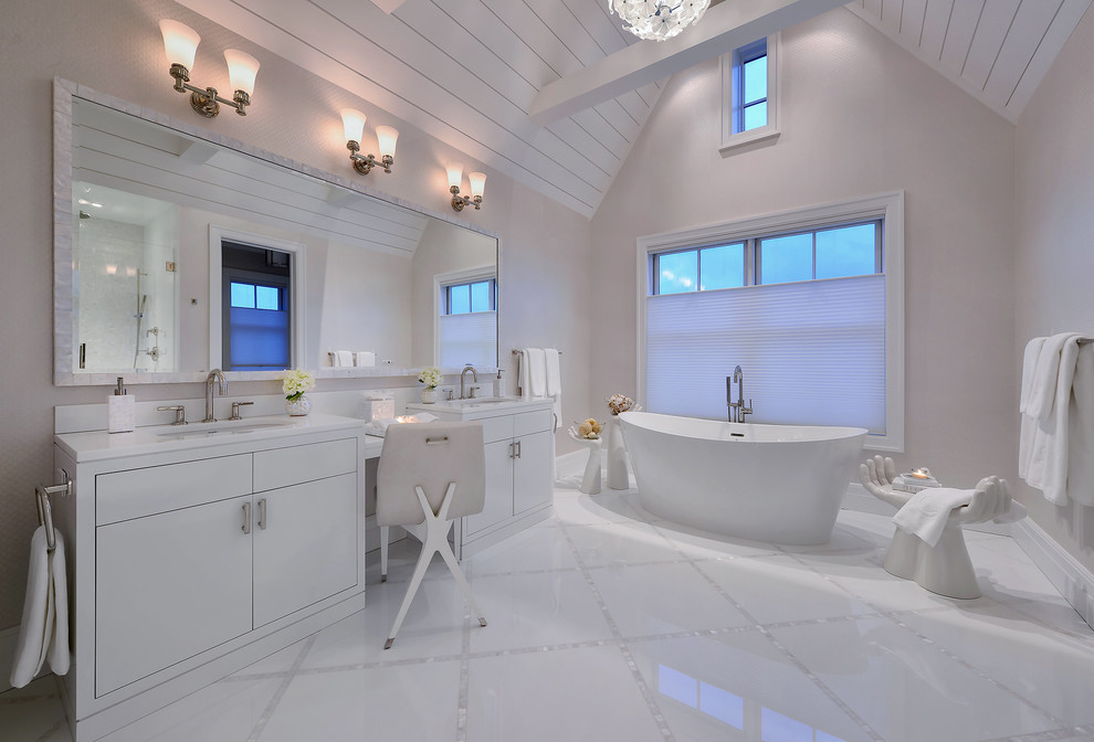 Bild på ett funkis en-suite badrum, med släta luckor, vita skåp, ett fristående badkar, grå väggar och ett undermonterad handfat