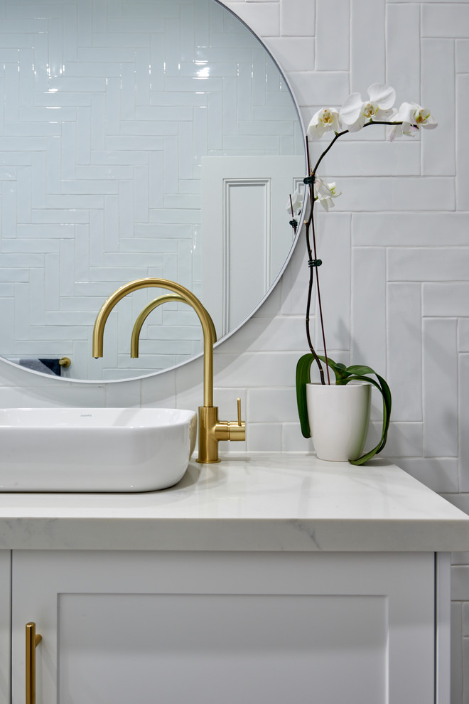 Design ideas for a large nautical ensuite wet room bathroom in Sydney with shaker cabinets, white cabinets, engineered stone worktops, a freestanding bath, a wall mounted toilet, white tiles, metro tiles, white walls, a vessel sink, an open shower, white worktops, ceramic flooring and brown floors.