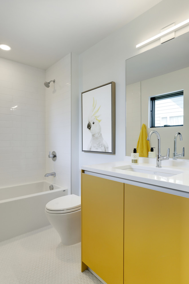 Modernes Duschbad mit flächenbündigen Schrankfronten, gelben Schränken, Badewanne in Nische, Duschbadewanne, weißen Fliesen, weißer Wandfarbe, weißem Boden und weißer Waschtischplatte in Minneapolis