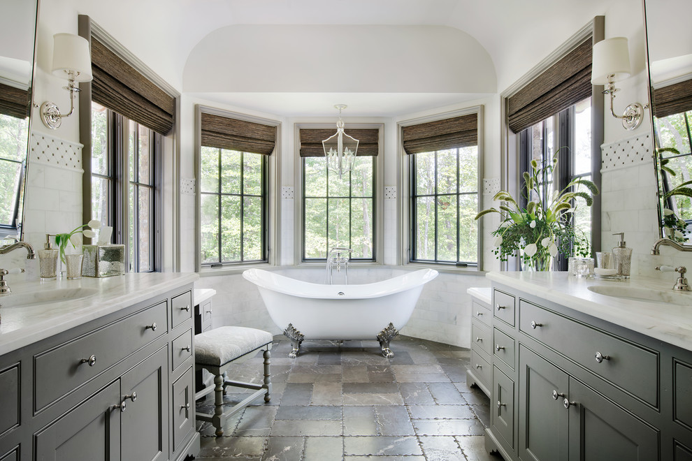 Bild på ett vintage badrum med dusch, med luckor med infälld panel, grå skåp, ett badkar med tassar, vit kakel, marmorkakel, vita väggar, marmorgolv, ett undermonterad handfat och grått golv