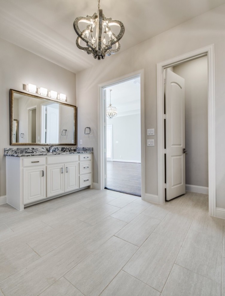 Exempel på ett stort klassiskt en-suite badrum, med luckor med upphöjd panel, vita skåp, ett platsbyggt badkar, en dusch/badkar-kombination, grå kakel, travertinkakel, grå väggar, klinkergolv i porslin, ett undermonterad handfat, granitbänkskiva, grått golv och med dusch som är öppen