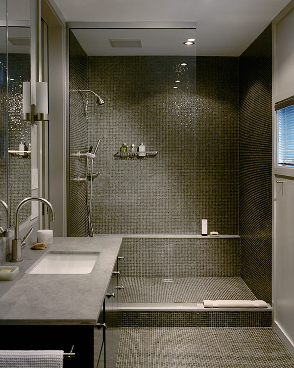 Esempio di una stanza da bagno padronale moderna di medie dimensioni con ante lisce, ante in legno bruno, doccia aperta, WC monopezzo, piastrelle nere, piastrelle di vetro, lavabo sottopiano e top in pietra calcarea
