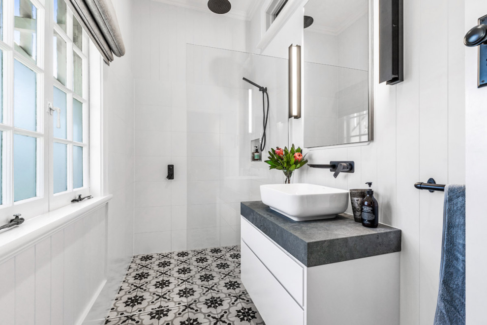 Inredning av ett nordiskt mellanstort grå grått badrum med dusch, med luckor med upphöjd panel, vita skåp, en öppen dusch, vit kakel, porslinskakel, vita väggar, klinkergolv i porslin, bänkskiva i betong, grått golv och med dusch som är öppen