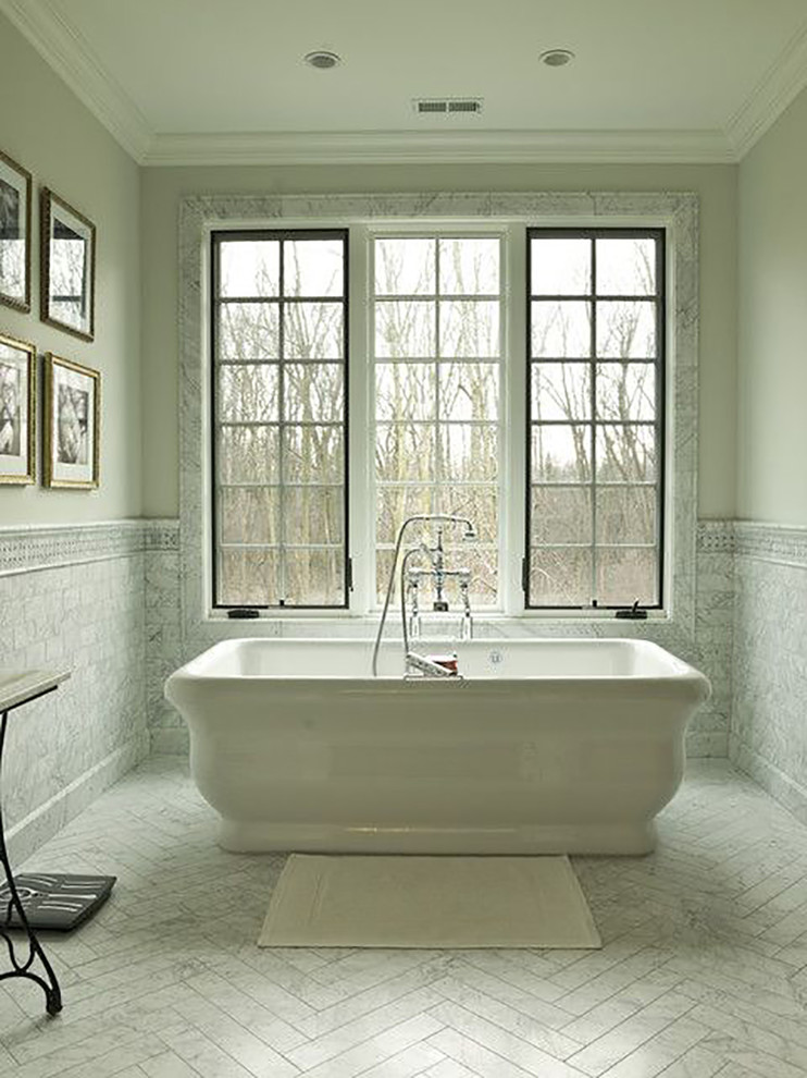 Idée de décoration pour une salle de bain tradition avec une baignoire indépendante, un carrelage blanc, un carrelage de pierre, un mur blanc et un sol en marbre.