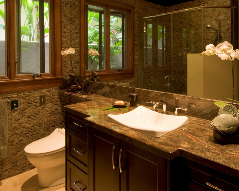 Mittelgroßes Duschbad mit Schrankfronten mit vertiefter Füllung, dunklen Holzschränken, Eckdusche, Toilette mit Aufsatzspülkasten, brauner Wandfarbe, Einbauwaschbecken, Quarzit-Waschtisch, beigem Boden, Falttür-Duschabtrennung und brauner Waschtischplatte in Hawaii