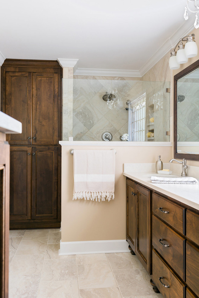 Example of a mid-sized transitional master beige tile limestone floor walk-in shower design in Atlanta with medium tone wood cabinets, an undermount sink, quartz countertops, recessed-panel cabinets and beige walls