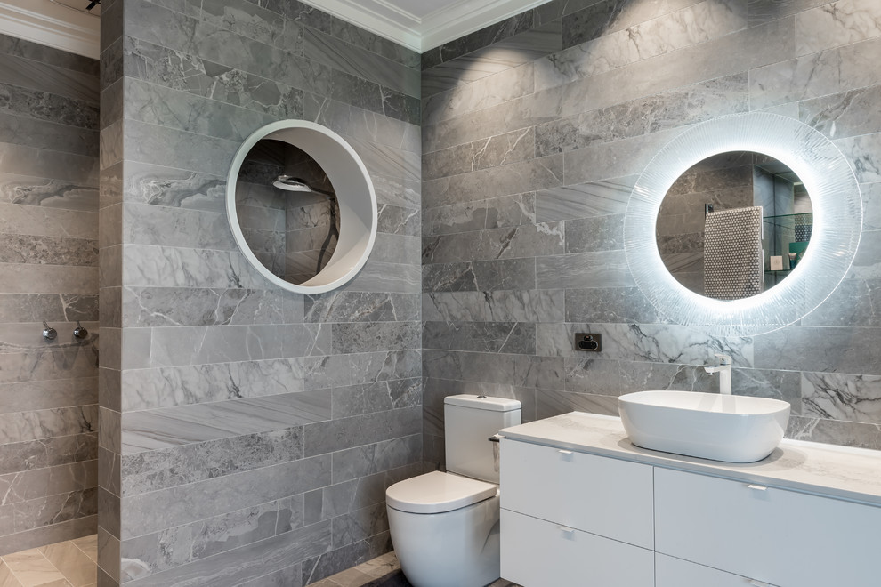 Foto di una stanza da bagno con doccia design con ante lisce, ante bianche, WC a due pezzi, piastrelle grigie, lavabo a bacinella, pavimento grigio, doccia aperta e top bianco