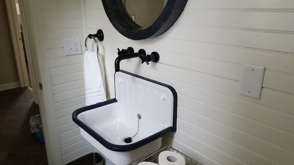 Cette image montre une petite salle d'eau urbaine avec WC séparés, un carrelage blanc, des carreaux de porcelaine, un mur blanc, un sol en carrelage de porcelaine et un lavabo suspendu.