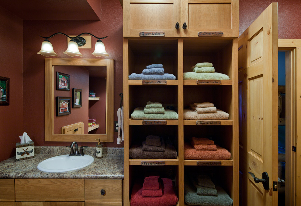 Esempio di una stanza da bagno padronale rustica di medie dimensioni con ante con riquadro incassato, ante in legno scuro, pareti rosse, lavabo da incasso e top in granito