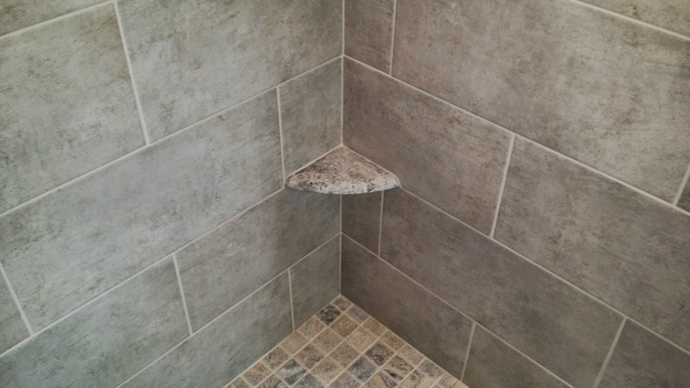 Idée de décoration pour une salle de bain principale tradition de taille moyenne avec une douche d'angle, un carrelage gris et des carreaux de céramique.