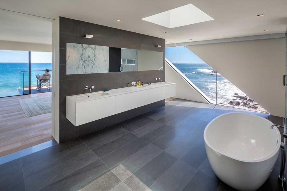 Идея дизайна: большая главная ванная комната в современном стиле с врезной раковиной, плоскими фасадами, белыми фасадами, мраморной столешницей, отдельно стоящей ванной, белыми стенами и полом из сланца