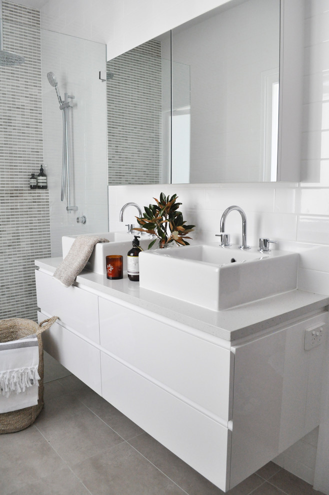 Modelo de cuarto de baño contemporáneo con lavabo sobreencimera y baldosas y/o azulejos blancos
