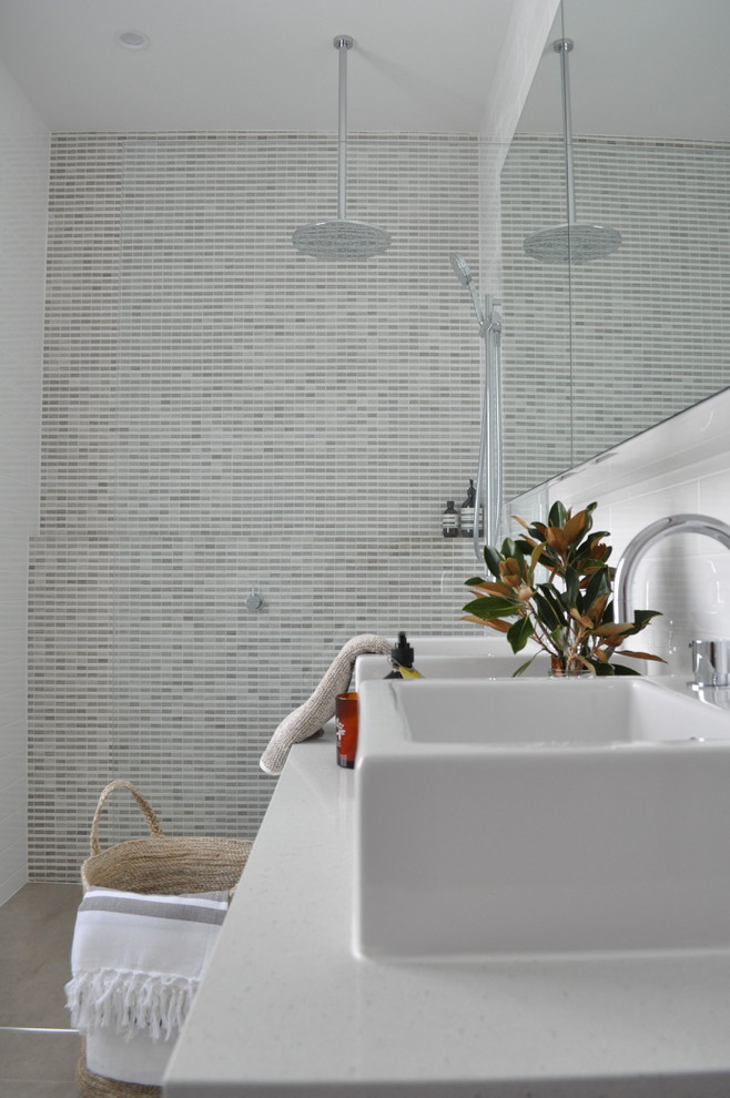 Cette image montre une salle de bain design avec une grande vasque, un placard à porte plane, des portes de placard blanches, un plan de toilette en quartz modifié, une douche ouverte, un carrelage multicolore, mosaïque, un mur blanc et un sol en carrelage de céramique.
