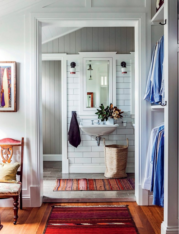 Réalisation d'une salle de bain champêtre de taille moyenne avec un lavabo suspendu, un sol en carrelage de céramique et un mur gris.