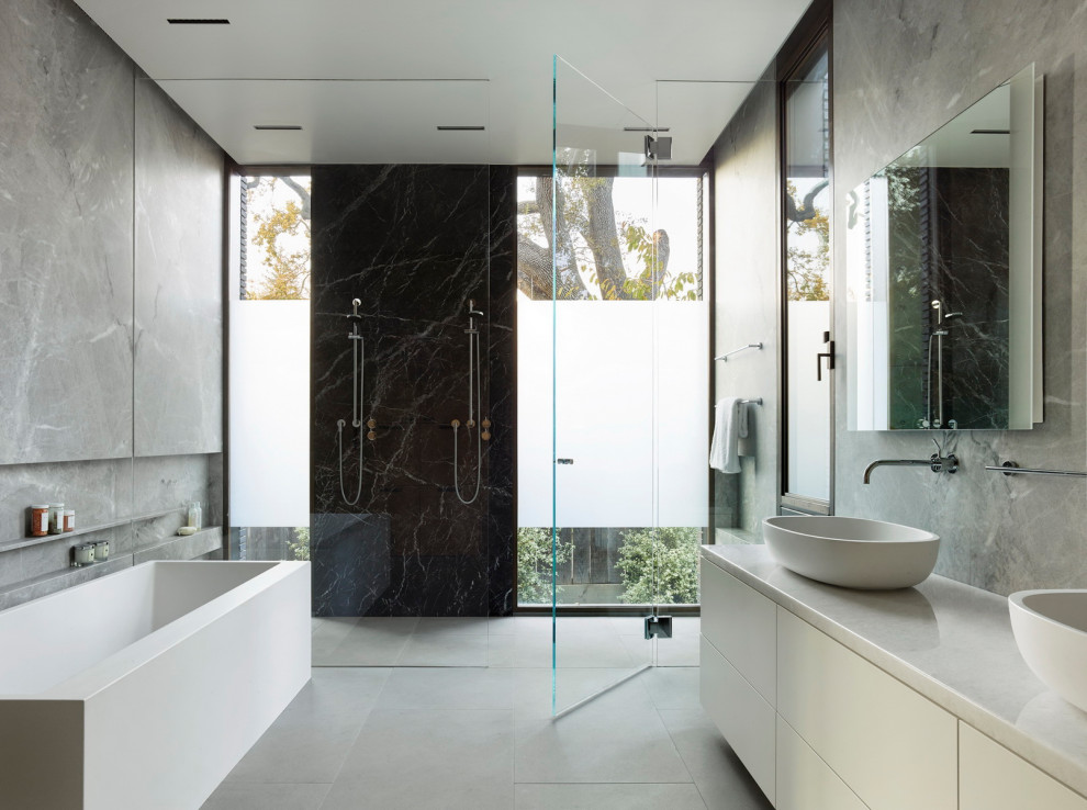 Ispirazione per una stanza da bagno minimalista con ante lisce, ante bianche, vasca freestanding, lavabo a bacinella, pavimento grigio e top bianco