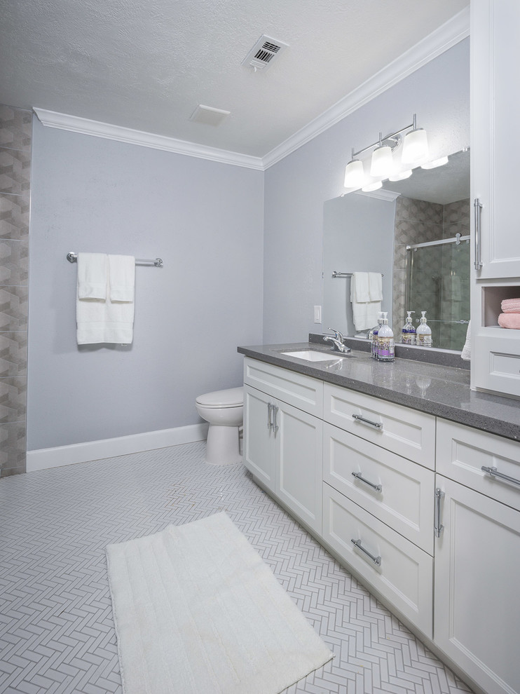 Idéer för att renovera ett mellanstort funkis grå grått en-suite badrum, med luckor med upphöjd panel, vita skåp, bänkskiva i kvarts, en dusch i en alkov, en toalettstol med separat cisternkåpa, grå kakel, porslinskakel, grå väggar, klinkergolv i keramik, ett undermonterad handfat, vitt golv och dusch med skjutdörr
