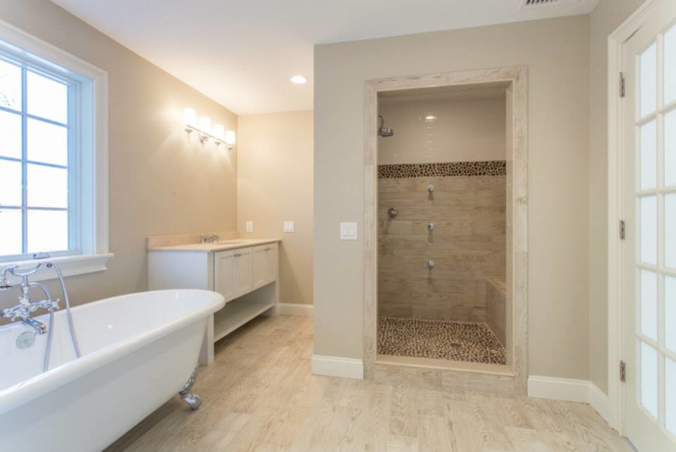 Diseño de cuarto de baño principal tradicional renovado grande con armarios con paneles empotrados, puertas de armario blancas, bañera con patas, ducha empotrada y paredes beige