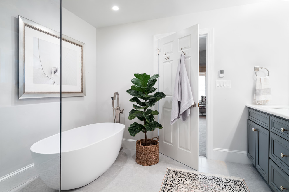 Inspiration for a mid-sized transitional master white tile and marble tile ceramic tile and gray floor bathroom remodel in Philadelphia with shaker cabinets, gray cabinets, a two-piece toilet, gray walls, a drop-in sink, quartzite countertops and a hinged shower door