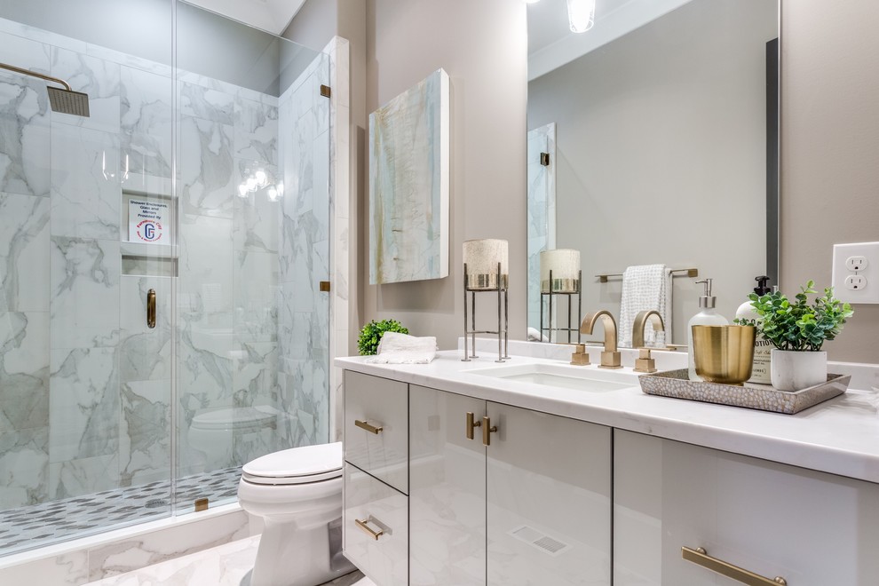 This is an example of a traditional shower room bathroom in Other with flat-panel cabinets, grey cabinets, an alcove shower, a two-piece toilet, grey tiles, white tiles, beige walls, a submerged sink, grey floors, a hinged door and white worktops.