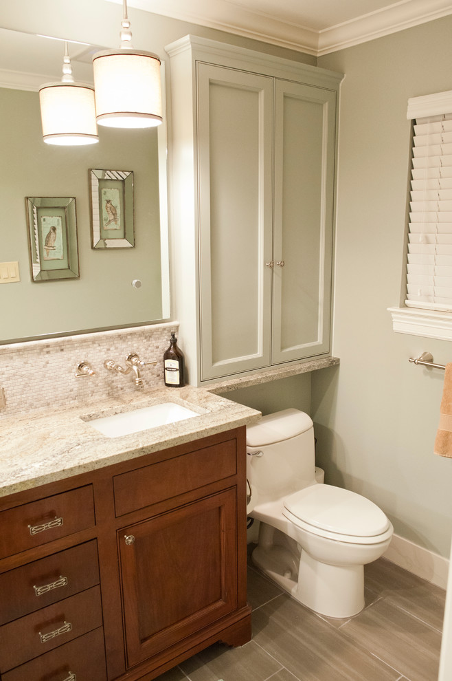 Foto på ett litet vintage badrum, med ett undermonterad handfat, luckor med infälld panel, skåp i mörkt trä, granitbänkskiva, en toalettstol med hel cisternkåpa, grå kakel, porslinskakel, gröna väggar och klinkergolv i porslin