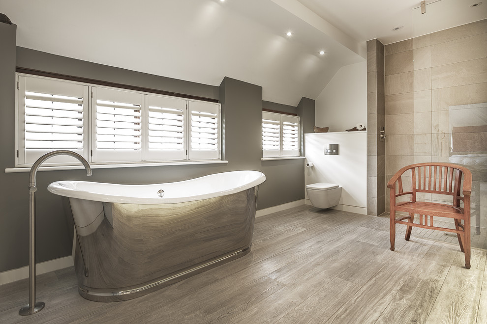 Photo of a large contemporary family bathroom in Hampshire with a freestanding bath, a wall mounted toilet, a walk-in shower, porcelain tiles, an open shower and porcelain flooring.