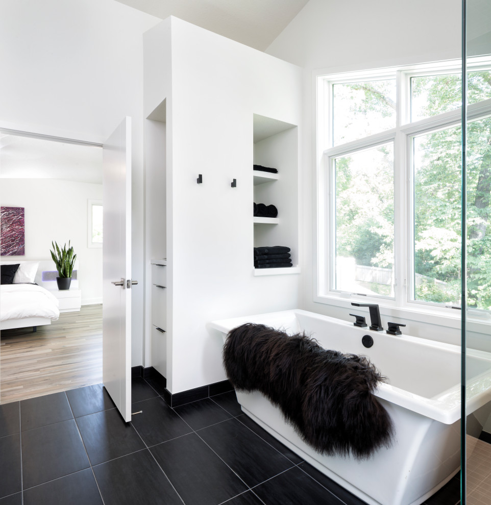 Large modern ensuite bathroom in Minneapolis with flat-panel cabinets, white cabinets, a freestanding bath, a built-in shower, a bidet, black tiles, porcelain tiles, white walls, porcelain flooring, a vessel sink, engineered stone worktops, black floors and white worktops.