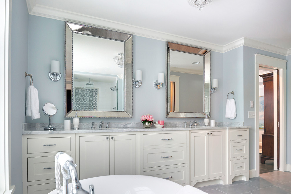 Klassisk inredning av ett en-suite badrum, med skåp i shakerstil, vita skåp, ett fristående badkar, grå kakel, blå väggar, klinkergolv i keramik och marmorbänkskiva