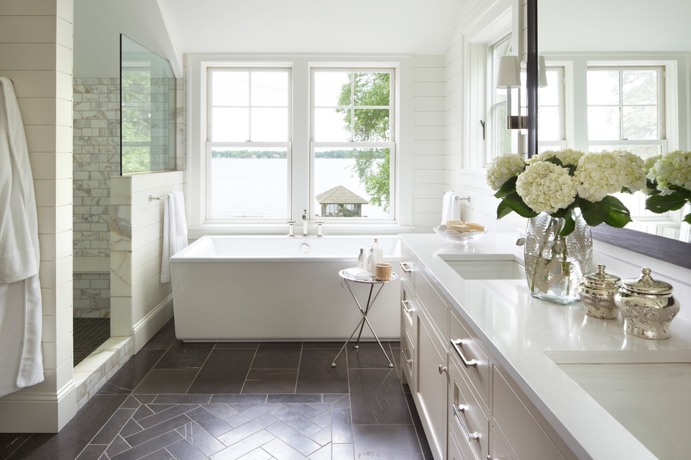Inspiration for a nautical bathroom in Minneapolis with shaker cabinets, beige cabinets, a freestanding bath, an alcove shower, white tiles, marble tiles, white walls, a submerged sink, grey floors and an open shower.