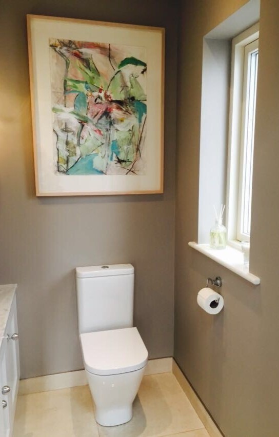 Kleine Gästetoilette mit Schrankfronten mit vertiefter Füllung, Wandtoilette mit Spülkasten, brauner Wandfarbe, Marmorboden, Aufsatzwaschbecken, Marmor-Waschbecken/Waschtisch und beigem Boden in Dublin