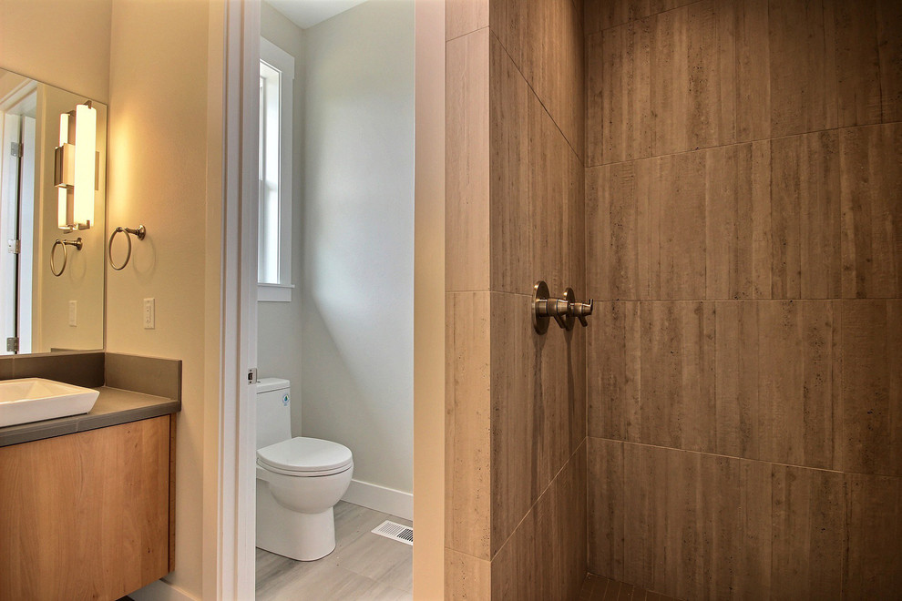 Cette image montre une très grande salle de bain principale minimaliste en bois brun avec un placard à porte plane, une douche à l'italienne, WC séparés, un carrelage gris, des carreaux de porcelaine, un mur beige, un sol en carrelage de céramique, une vasque, un plan de toilette en carrelage, un sol gris, aucune cabine et un plan de toilette gris.