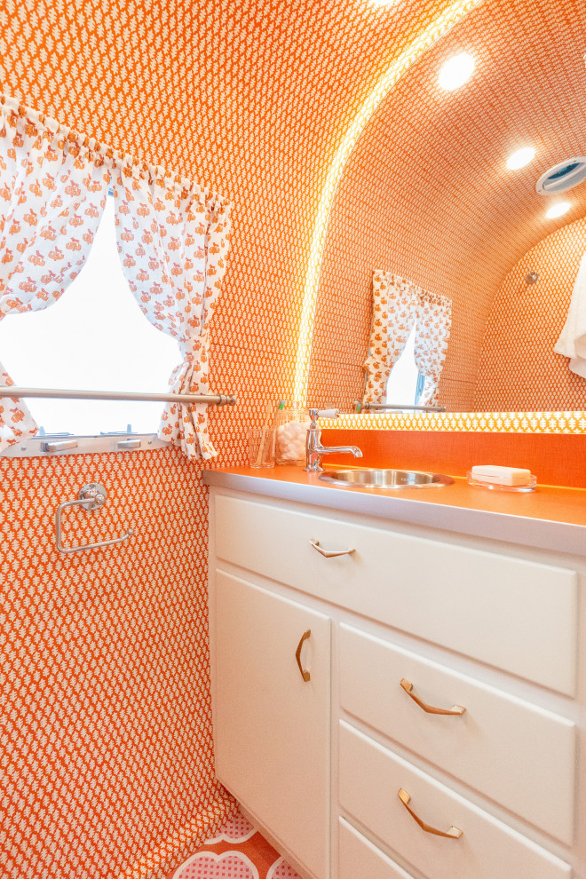 Esempio di una piccola stanza da bagno con doccia bohémian con ante lisce, ante bianche, WC monopezzo, piastrelle arancioni, pareti arancioni, pavimento in legno verniciato, lavabo da incasso, top in laminato, pavimento arancione e top arancione