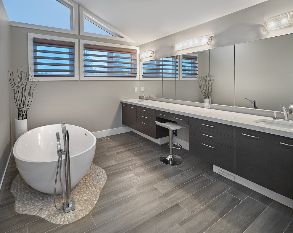 Inspiration for a mid-sized modern master freestanding bathtub remodel in Calgary with medium tone wood cabinets, a one-piece toilet, gray walls and an undermount sink