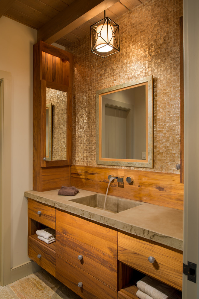 Réalisation d'une salle de bain tradition en bois brun avec un lavabo intégré, un placard à porte plane, un plan de toilette en béton, un carrelage beige, un mur beige et un sol en travertin.