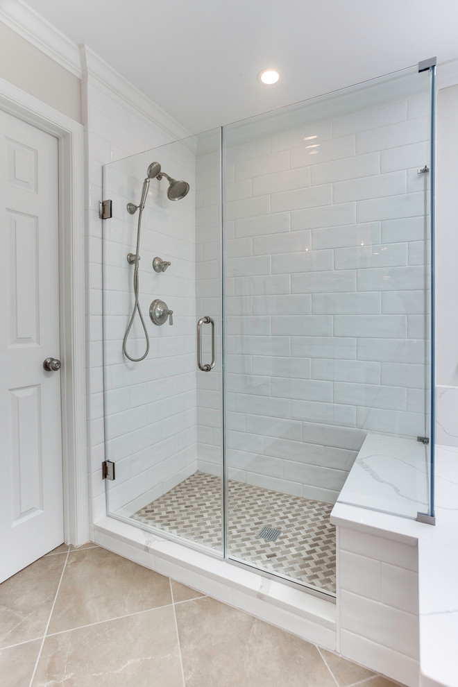 This is an example of a classic ensuite bathroom in DC Metro with shaker cabinets, white cabinets, a built-in bath, a two-piece toilet, white tiles, ceramic tiles, porcelain flooring, a submerged sink, engineered stone worktops, brown floors, a hinged door and white worktops.
