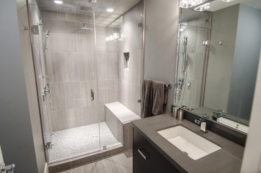 Foto på ett mellanstort funkis badrum med dusch, med släta luckor, svarta skåp, en dusch i en alkov, en toalettstol med separat cisternkåpa, grå kakel, keramikplattor, grå väggar, klinkergolv i keramik och ett undermonterad handfat