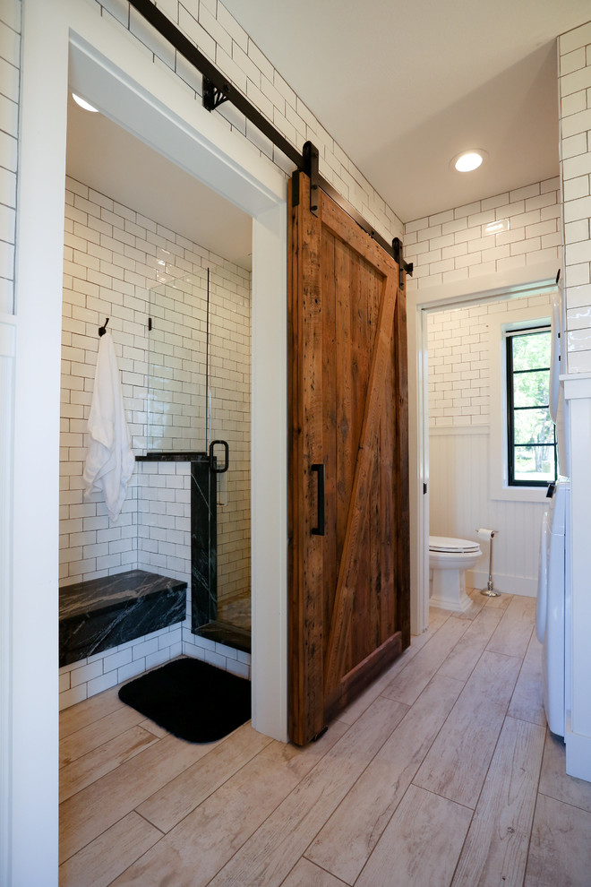 This is an example of a medium sized classic ensuite bathroom in Other with recessed-panel cabinets, white cabinets, a walk-in shower, a two-piece toilet, white tiles, metro tiles, white walls, light hardwood flooring, a vessel sink and soapstone worktops.