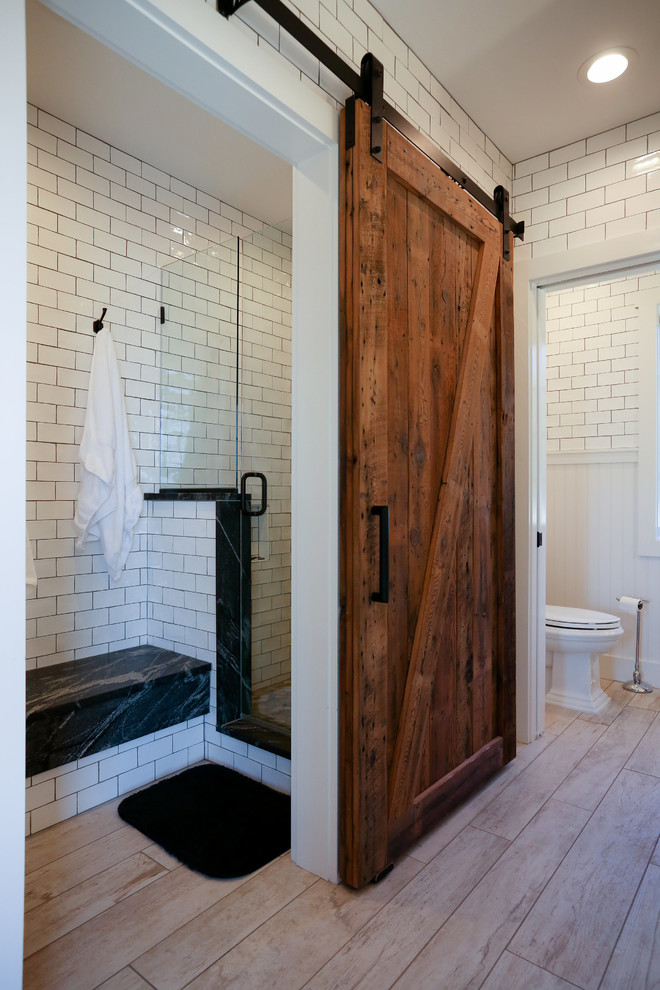 Doorless shower - mid-sized transitional master white tile and subway tile light wood floor doorless shower idea in Other with recessed-panel cabinets, white cabinets, a two-piece toilet, white walls, a vessel sink and soapstone countertops