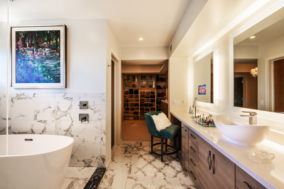 ハワイにある広いモダンスタイルのおしゃれなマスターバスルーム (フラットパネル扉のキャビネット、中間色木目調キャビネット、置き型浴槽、白いタイル、大理石タイル、白い壁、大理石の床、ベッセル式洗面器、白い床、白い洗面カウンター) の写真