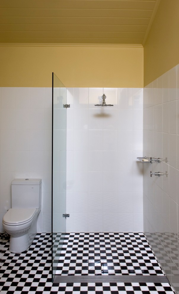 Пример оригинального дизайна: маленькая главная ванная комната в викторианском стиле с фасадами островного типа, черными фасадами, душем в нише, унитазом-моноблоком, черно-белой плиткой, желтыми стенами, полом из травертина, настольной раковиной, белым полом и открытым душем для на участке и в саду