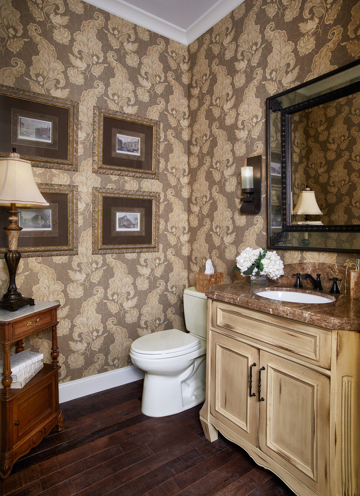 Cette photo montre une petite salle d'eau chic en bois vieilli avec un plan de toilette en granite, un mur jaune, parquet foncé, un placard avec porte à panneau encastré, WC séparés et un lavabo encastré.