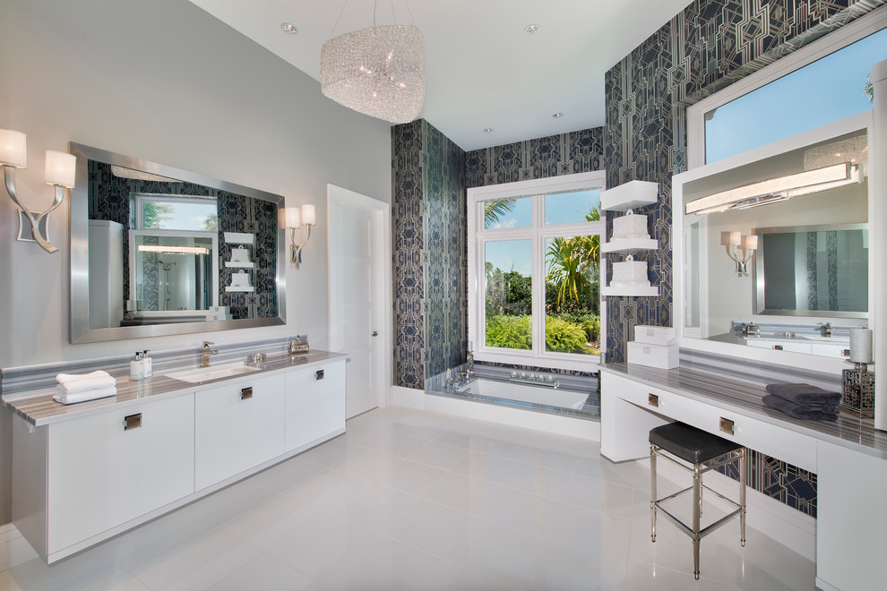 Imagen de cuarto de baño principal actual con armarios con paneles lisos, puertas de armario blancas, bañera encastrada sin remate, paredes grises, lavabo bajoencimera y ventanas