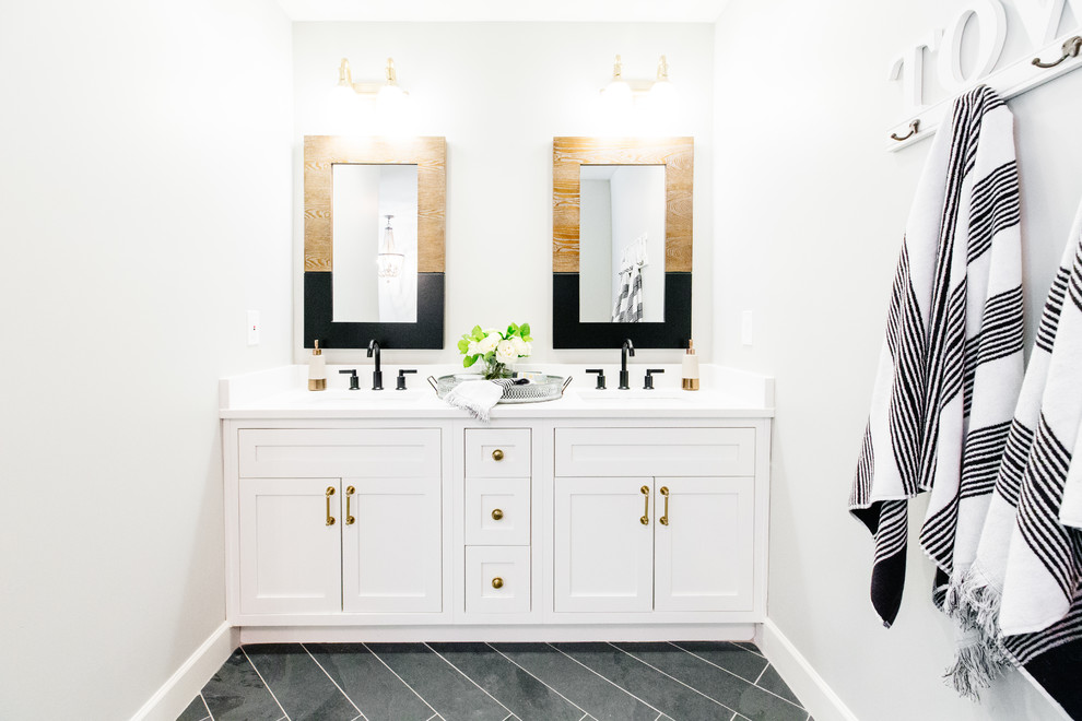 Inspiration for a large farmhouse master white tile and marble tile slate floor and black floor bathroom remodel in Phoenix with recessed-panel cabinets, white cabinets, gray walls, a drop-in sink, quartz countertops and a hinged shower door