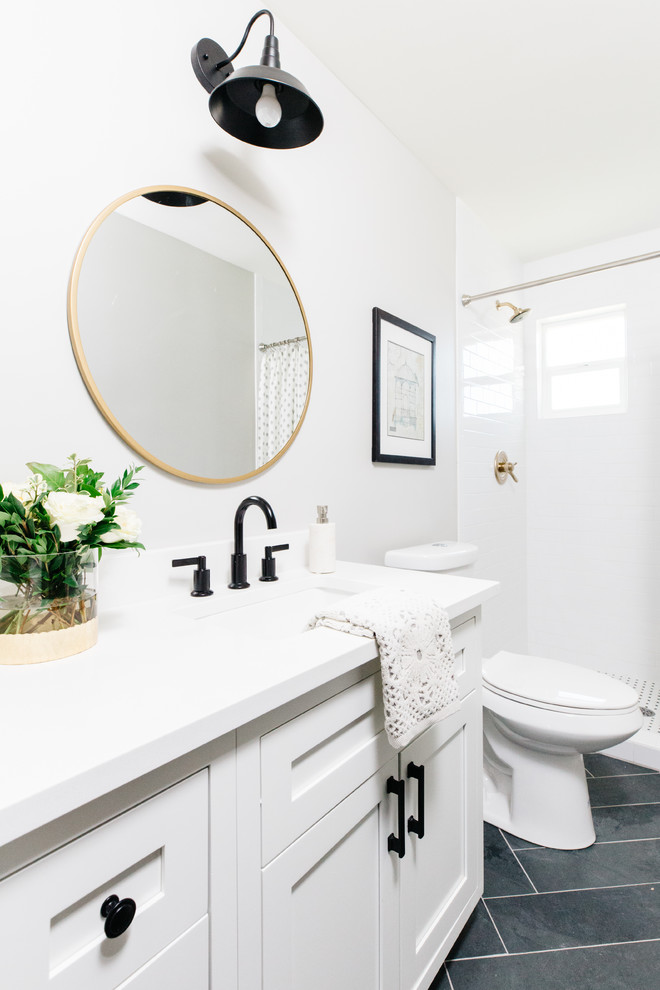 Klassisk inredning av ett badrum med dusch, med skåp i shakerstil, vita skåp, en dusch i en alkov, vit kakel, tunnelbanekakel, vita väggar, skiffergolv, ett undermonterad handfat, svart golv och dusch med duschdraperi