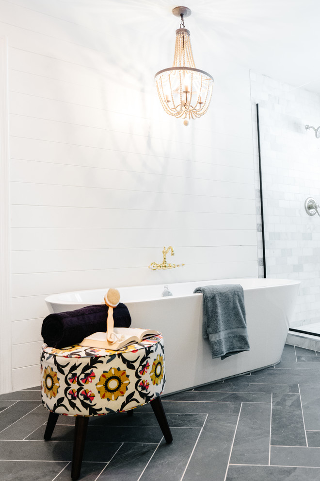 This is an example of a large country ensuite bathroom in Phoenix with a freestanding bath, a walk-in shower, white tiles, marble tiles, slate flooring, black floors and a hinged door.