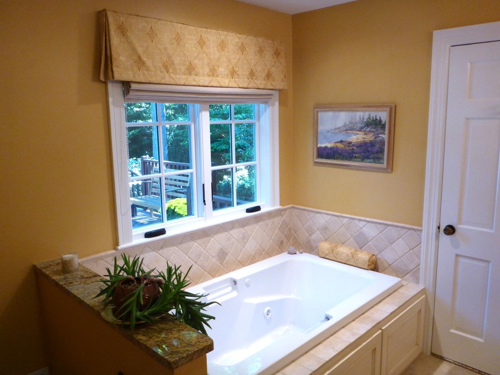 Mid-sized elegant master beige tile and stone tile ceramic tile and beige floor drop-in bathtub photo in Boston with recessed-panel cabinets, distressed cabinets, granite countertops, a drop-in sink and yellow walls