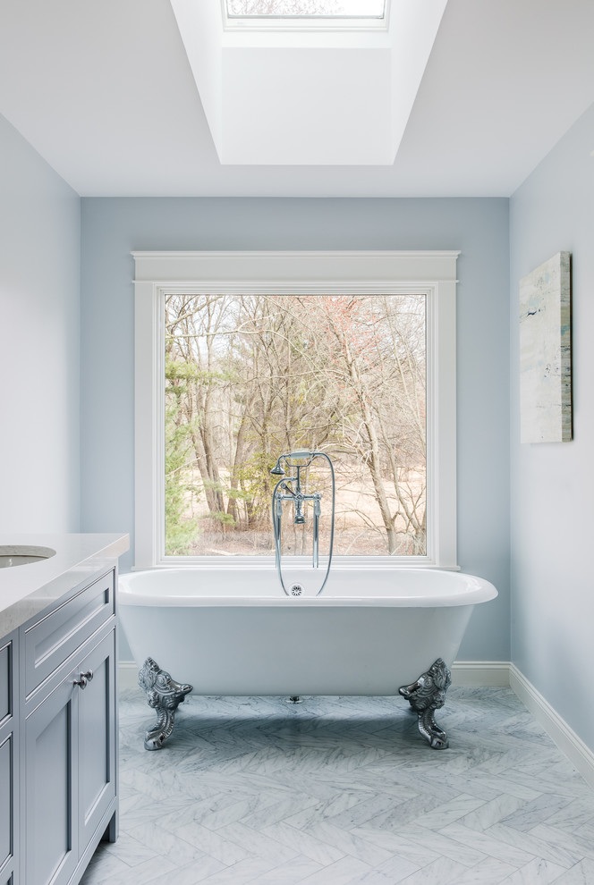 Bild på ett stort vintage en-suite badrum, med ett badkar med tassar, blå kakel, keramikplattor, blå väggar, marmorgolv, bänkskiva i kvarts, luckor med profilerade fronter och blå skåp