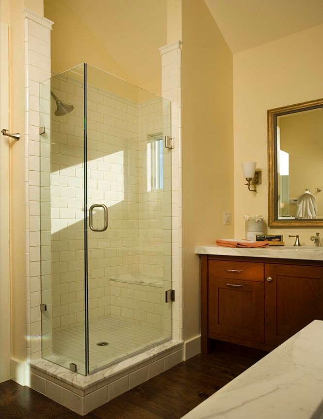 На фото: большая главная ванная комната в классическом стиле с фасадами с утопленной филенкой, фасадами цвета дерева среднего тона, угловым душем, белой плиткой, плиткой кабанчик, бежевыми стенами и темным паркетным полом